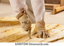 Man cutting insulation material for building