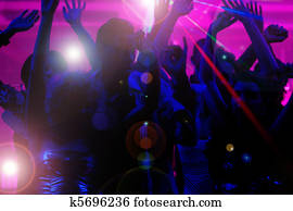 People dancing in club with laser