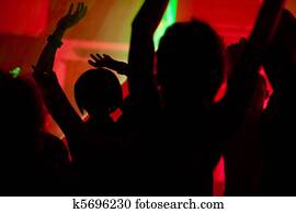 People dancing in club with laser