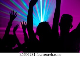 People dancing in club with laser