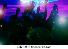 People dancing in club with laser