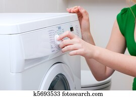 Woman washing clothes with machine