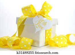 Yellow theme gift box with yellow polka dot ribbon and white copy space for Easter, birthday, wedding, baby or bridal shower present. Yellow theme gift box with yellow polka dot ribbon and white copy space for Easter, birthday, wedding, baby or bridal shower present.