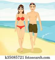 happy couple walking along a beach happy couple walking along a beach