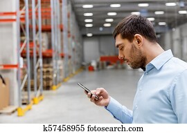 homem negócios, com, smartphone, em, armazém