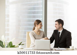 sonriente, hombre de negocios, sacudarir las manos, con, mujer de negocios, en, oficina