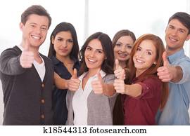 We are successful team! Group of cheerful young people standing close to each other and gesturing