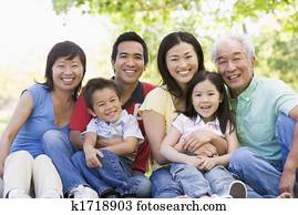 Extended family sitting outdoors smiling Extended family sitting outdoors smiling