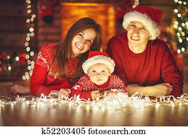 happy family mother father and baby at christmas tree at home
