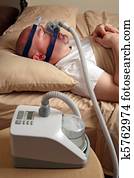 Man with sleep apnea using a CPAP machine