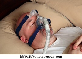 Man with sleep apnea using a CPAP machine