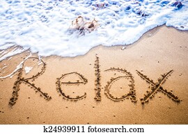 Relax written into the sand on a beach Relax written into the sand on a beach