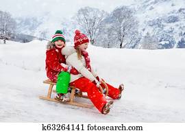 Kids play in snow. Winter sleigh ride for children Kids play in snow. Winter sleigh ride for children
