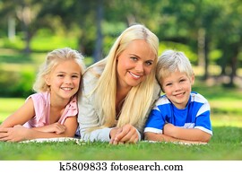 Mother with her children lying down in the park Mother with her children lying down in the park