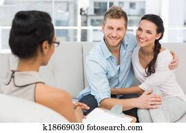 Smiling couple reconciling at therapy session Smiling couple reconciling at therapy session