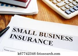 Small business insurance policy on a wooden desk. Small business insurance policy on a wooden desk.