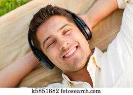Young man listening to music in the park Young man listening to music in the park