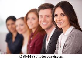 leute, an, dass, seminar., attraktive, junge frau, lächeln, kamera, während, andere, leute, sitzen, hinter, sie, reihe