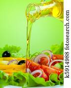 olive oil stream and healthy fresh vegetable salad