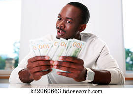 Portrait of a happy african man holding US dollars Portrait of a happy african man holding US dollars