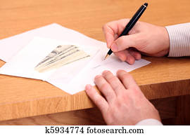 A businessman signing a contract and getting money for it A businessman signing a contract and getting money for it