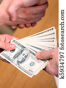 Businessman setting a deal passing money and shaking hands Businessman setting a deal passing money and shaking hands