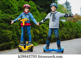 Happy boys riding on hoverboards or gyroscooters outdoor