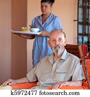 senior with carer or nurse bringing meal senior with carer or nurse bringing meal