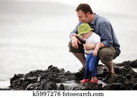 Dad with little son walking outdoors at ocean Dad with little son walking outdoors at ocean