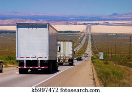 Interstate delivery trucks on a highway.