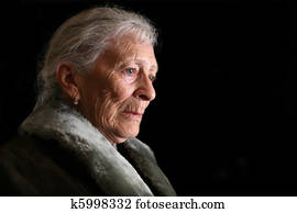 Portrait of a senior woman contemplating. Isolated on black background.