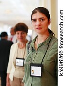 Two business women at trade show with name badges. Two business women at trade show with name badges.