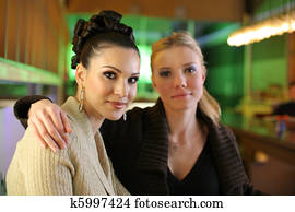 Two female friends in colorful office.