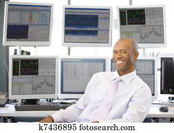 Portrait Of Stock Trader In Front Of Computer Monitors