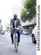 African American business man riding a bike in the street African American business man riding a bike in the street