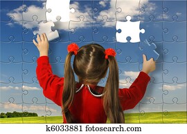 The girl assemble big puzzle