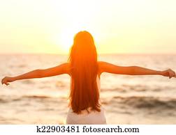 Free woman enjoying freedom feeling happy at beach at sunset. Be