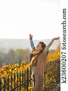 Happy young woman in autumn outdoors rejoicing