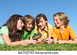 kids at summer camp playing with magnifying glass kids at summer camp playing with magnifying glass