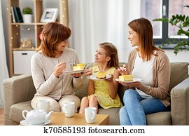mother, daughter and grandmother eating cake mother, daughter and grandmother eating cake