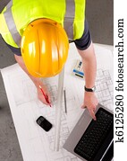 Builder inspects construction plans.