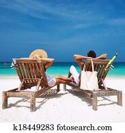 Couple in white relax on a beach at Maldives