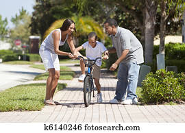 afrikansk amerikansk familie, med, guttriing bike, &, glad, foreldre