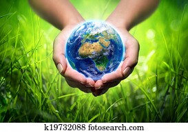 earth in hands - grass background earth in hands - grass background