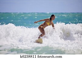 girl in a yellow bikini surfing in Hawaii girl in a yellow bikini surfing in Hawaii