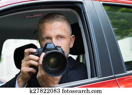 Man Photographing With Slr Camera From Car