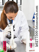 medical researcher using microscope