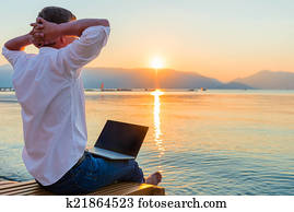 Recreational entrepreneur. Man with laptop in the morning on the Recreational entrepreneur. Man with laptop in the morning on the