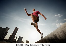 hispanic man running and jumping from a wall