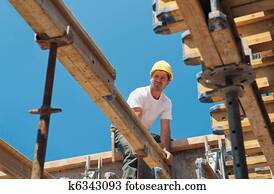Construction worker placing formwork beams Construction worker placing formwork beams